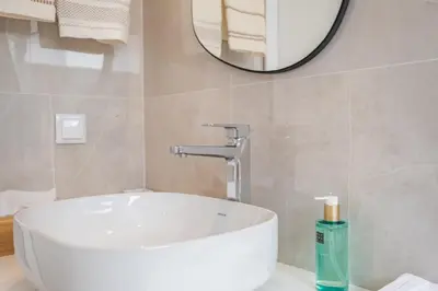 a bathroom with a white sink and a mirror at Casa Buganvília in Funchal