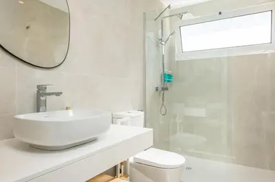 a bathroom with a sink and a toilet and a mirror at Casa Buganvília in Funchal