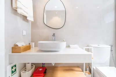 a white bathroom with a sink and a mirror at Casa Buganvília in Funchal