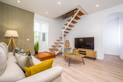 a living room with a couch and a tv at Casa Buganvília in Funchal