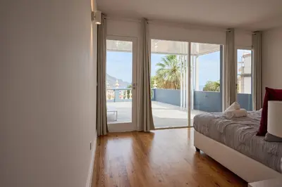 a bedroom with a bed and a large glass door at Luna Rossa by Homie in Funchal