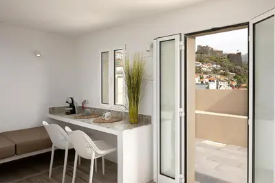 a bathroom with a counter with chairs and a sink at Luna Rossa by Homie in Funchal