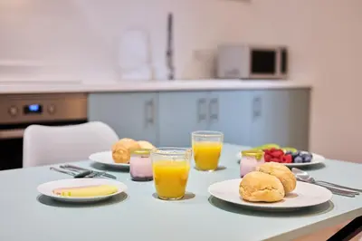 a table with plates of food and glasses of orange juice at Luna Rossa by Homie in Funchal