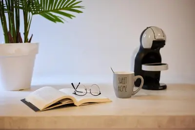 a book and glasses on a table with a coffee mug at Luna Rossa by Homie in Funchal