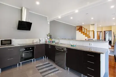 a kitchen with black cabinets and a counter top at Casa Estrela Do Norte in Ponta Delgada
