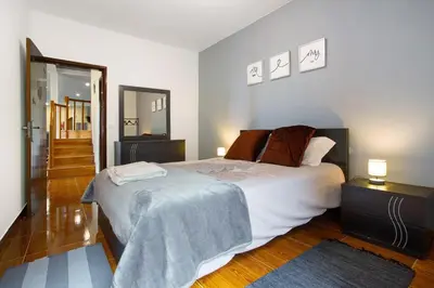 a bedroom with a large bed and a mirror at Casa Estrela Do Norte in Ponta Delgada