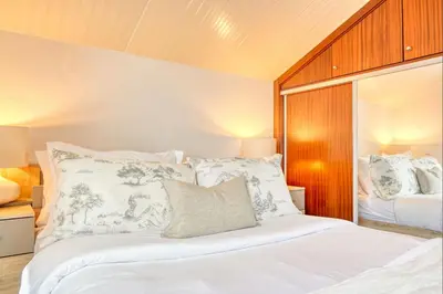 a bedroom with a bed with white sheets and pillows at Cantinho da Mikaela, A Home in Madeira in Ponta do Sol