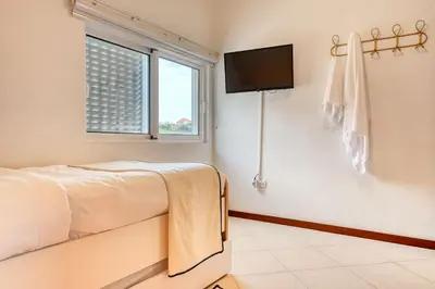 a bedroom with a bed and a tv on the wall at Cantinho da Mikaela, A Home in Madeira in Ponta do Sol
