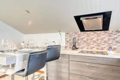 a kitchen with a table with chairs and a stove at Cantinho da Mikaela, A Home in Madeira in Ponta do Sol