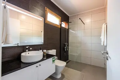 a bathroom with a sink and a toilet and a mirror at Praia Encantada in Porto Santo