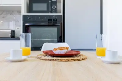 a table with a plate of food and orange juice at Villa Machico Valley in Machico