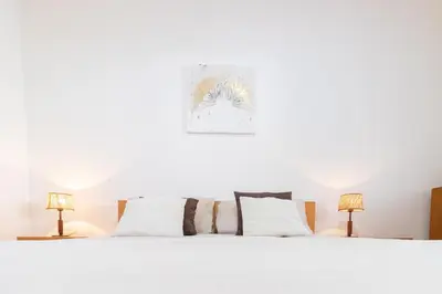 a bedroom with a white bed with two lamps at Villa Machico Valley in Machico