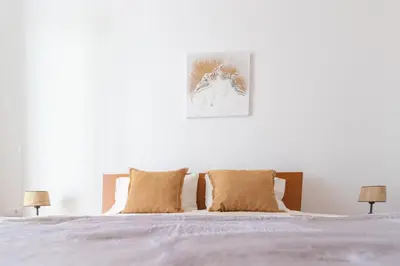 a white bedroom with a bed with two lamps at Villa Machico Valley in Machico