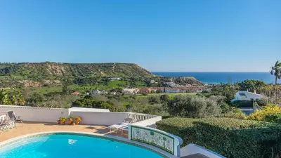 a villa with a swimming pool and a view of the ocean at Casa das Palmeiras, Luxury Villa in Luz