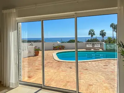 a view of a swimming pool through sliding glass doors at Casa das Palmeiras, Luxury Villa in Luz