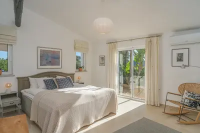 a bedroom with a bed and a large window at Casa das Palmeiras, Luxury Villa in Luz