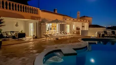 a villa with a swimming pool at night at Casa das Palmeiras, Luxury Villa in Luz