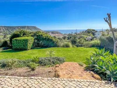 a garden with green grass and bushes at Casa das Palmeiras, Luxury Villa in Luz