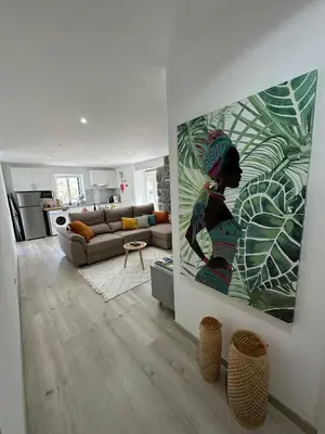 a living room with a couch and a painting on the wall at The Green Valley House in São Vicente