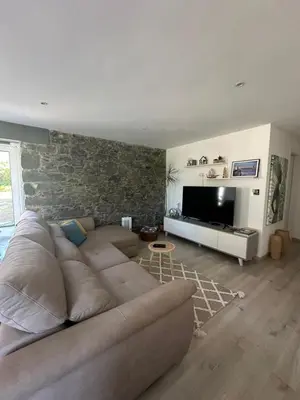 a living room with a couch and a flat screen tv at The Green Valley House in São Vicente