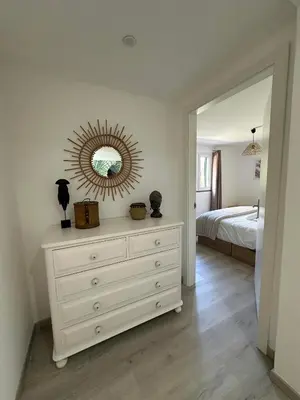 a bedroom with a dresser with a mirror and a bed at The Green Valley House in São Vicente