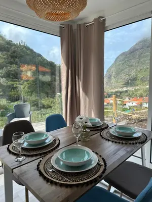 a dining room table with a view of a mountain at The Green Valley House in São Vicente