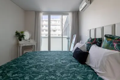 a bedroom with a green bed with a window at Funchal Plaza in Funchal