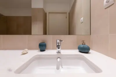 a bathroom sink with two blue vases on it at Funchal Plaza in Funchal