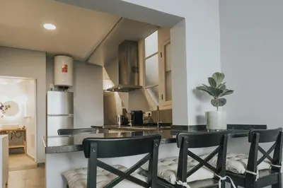 a kitchen with black chairs and a counter top at Pico Apartment's in Câmara de Lobos