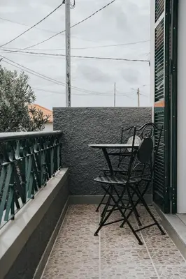 a table and chair sitting on a balcony at Pico Apartment's in Câmara de Lobos