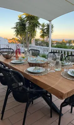 a wooden table with glasses and plates on it at Exklusive Luxusvilla - Meerblick - beheizter Pool in Mato Porcas