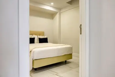 a bedroom with a bed with white sheets and black pillows at Beco Santa Emilia 4O, a Home in Madeira in Funchal