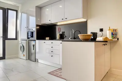 a kitchen with white cabinets and a sink at Beco Santa Emilia 4O, a Home in Madeira in Funchal