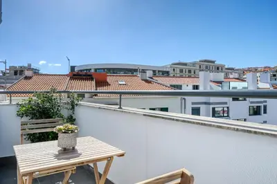 a balcony with a table and a view of a city at Beco Santa Emilia 4O, a Home in Madeira in Funchal