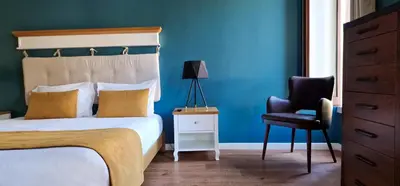 a bedroom with blue walls and a bed and a chair at Caracas Escape by LovelyStay in Funchal