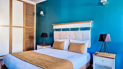 a blue bedroom with a bed with a blue wall at Caracas Escape by LovelyStay in Funchal