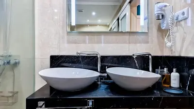 two white sinks on a black counter in a bathroom at Caracas Escape by LovelyStay in Funchal
