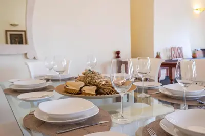 a table with glasses and plates and food on it at Vivenda Alves by GALMI in Gaula