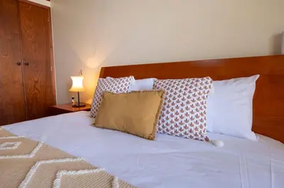 a bedroom with a bed with white sheets and pillows at Vivenda Alves by GALMI in Gaula