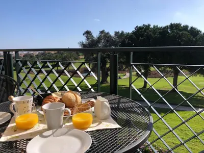 a table with a breakfast of bread and orange juice at Casa com Vista in Lagos
