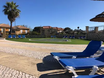 a couple of blue lounge chairs and an umbrella at Casa com Vista in Lagos