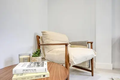 a chair and a book on a table at Beco Santa Emilia 4P, a Home in Madeira in Funchal