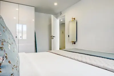 a bedroom with a white bed and a mirror at Beco Santa Emilia 4P, a Home in Madeira in Funchal