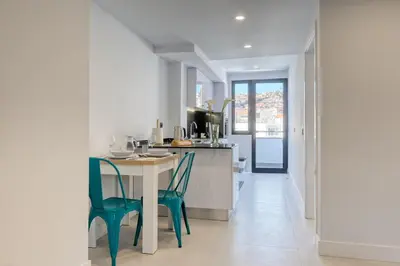 a kitchen with a white table and chairs at Beco Santa Emilia 4P, a Home in Madeira in Funchal