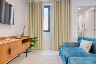 a living room with a blue couch and a tv at Beco Santa Emilia 4P, a Home in Madeira in Funchal