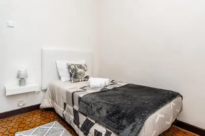 a small bedroom with a bed with a black blanket at Achada House - Traditional House in Calheta