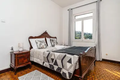 a bedroom with a bed and a window at Achada House - Traditional House in Calheta