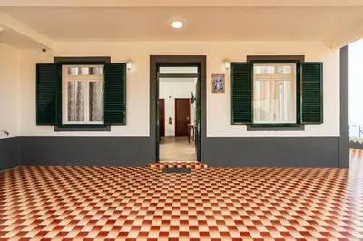 a room with two windows and a checkered floor at Achada House - Traditional House in Calheta