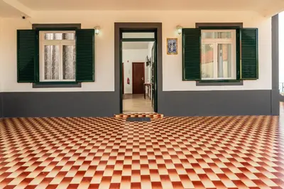 a house with green windows and a checkered floor at Achada House - Traditional House in Calheta