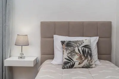 a bed with a pillow and a lamp on a table at Achada House - Traditional House in Calheta